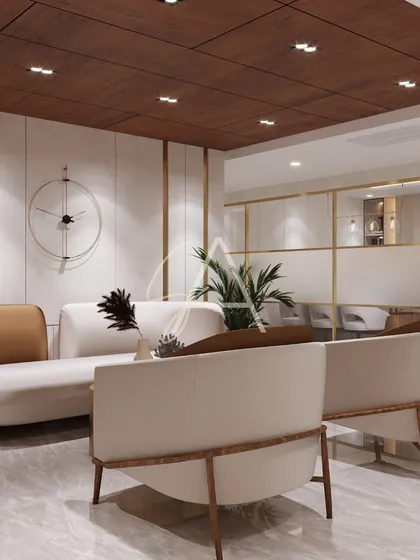 This visitors' lounge combines comfort with corporate elegance. We used a warm, neutral palette with beige and tan upholstery, accented by a dark wood ceiling and subtle gold trim to create a welcoming and high-end feel.