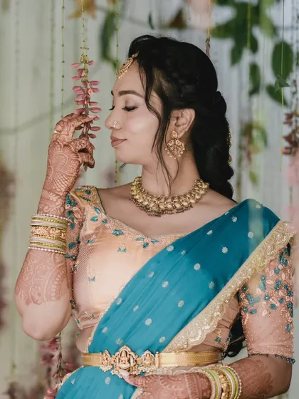 A beautiful candid shot of Hema. The makeup is designed to look flawless in natural light, perfect for daytime engagement ceremonies.