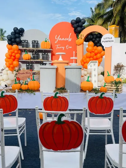 The full seating area for the pumpkin-themed party, with custom pumpkin cutouts on the back of each chair.