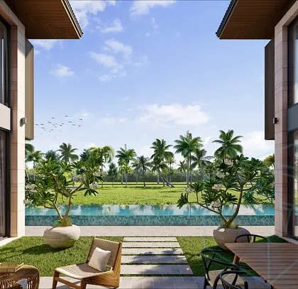 A view from inside a Goa villa, looking out towards the paddy fields. The architecture is designed to frame the landscape, with two wings of the house creating a private courtyard that opens up to the stunning natural vista.