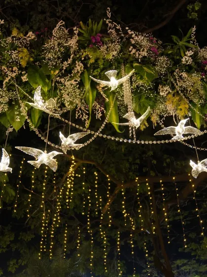 I love adding unique touches like these illuminated crystal birds hanging from a floral arrangement. Paired with cascading fairy lights, they created a truly magical canopy for the event.