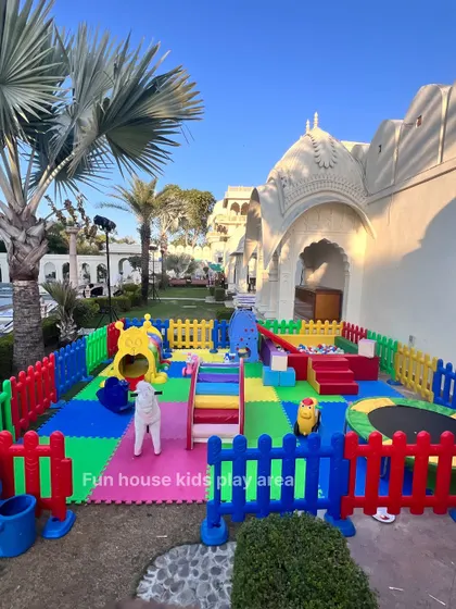 Our rainbow play area set up outdoors at the Shiv Vilas Resort, featuring a slide, trampoline, rockers, and a ball pit surrounded by a colorful fence.