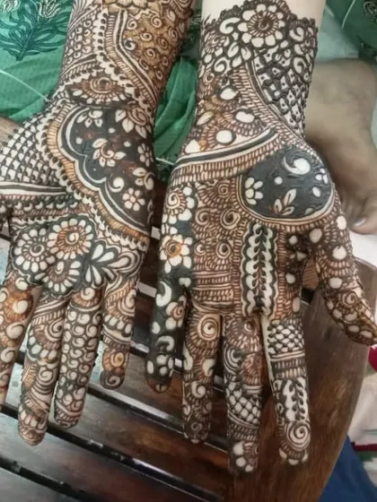 This design shows how different patterns can work together on each hand to create a unique yet coordinated look. One palm features a large floral negative space, while the other has denser work.