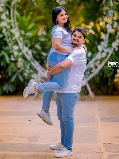 A fun and joyful lift in a garden setting. This shot is full of energy and happiness, perfectly capturing the couple's excitement.