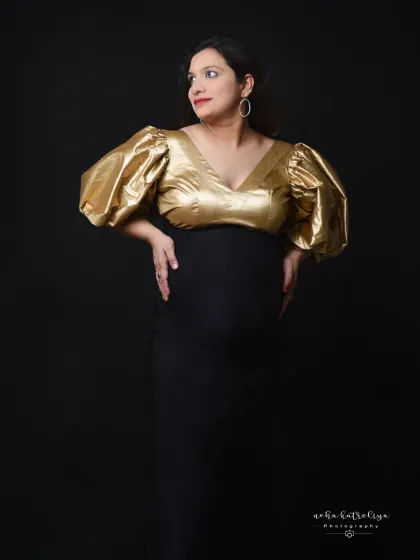 A bold and stylish choice. This black gown with dramatic puffy gold sleeves makes a powerful fashion statement.