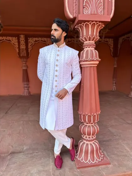 This full-length shot shows our white sherwani paired with contrasting maroon loafers, a great way to add a pop of color to a monochrome look.