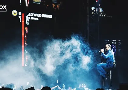 King in a quiet, emotional moment on stage, seated amidst a cloud of smoke. I create space for both high-energy bangers and intimate performances.