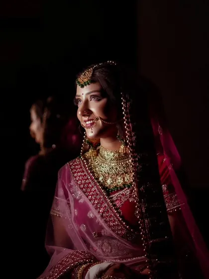 A smiling bride in a low-key setting, her happiness shining through the dramatic lighting.