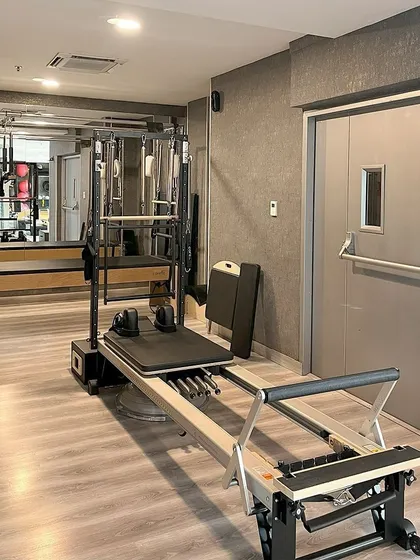 A look into our studio where the Cadillac and Reformer machines stand ready. The clean, organized space ensures a safe and effective workout.