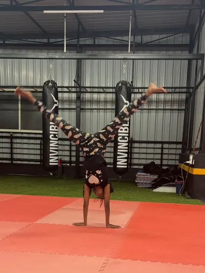 This student is mastering her handstand straddle, showing great balance and control.