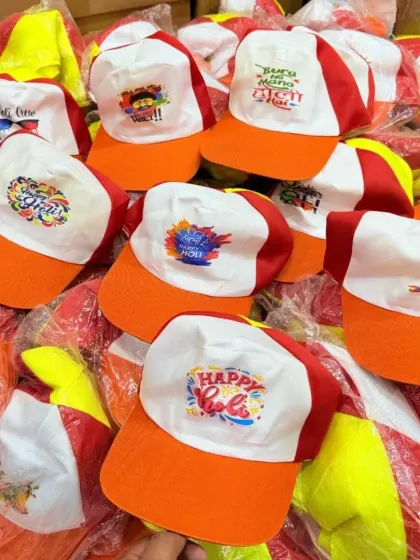 A pile of custom-printed caps for Holi celebrations. I can print colorful designs and fun Hindi slogans to get your team into the festive spirit.