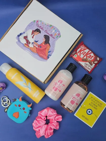 A budget-friendly Rakhi hamper that's still full of love. This gift for a sister includes body care items, a scrunchie, a cute coin pouch, a KitKat, and a greeting card.