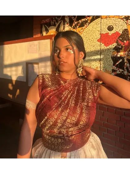 A closer look at the draped top and the creative makeup for this fusion look. The styling extends to the face gems and armlet, tying the whole theme together.
