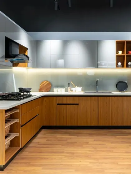 This L-shaped kitchen features a warm wood finish on the lower cabinets, paired with glossy gray upper cabinets. The design is both modern and inviting.