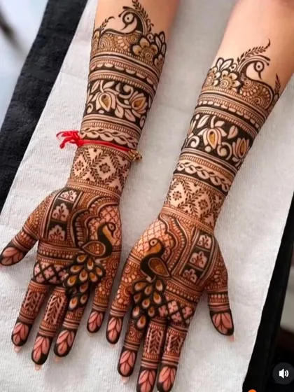 This design showcases beautiful peacock figures on the palms and wrist, combined with floral bands and geometric patterns for a balanced and traditional bridal look.