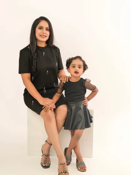 A stylish mother and daughter duo. This classic studio portrait with matching outfits showcases their confident and loving relationship.