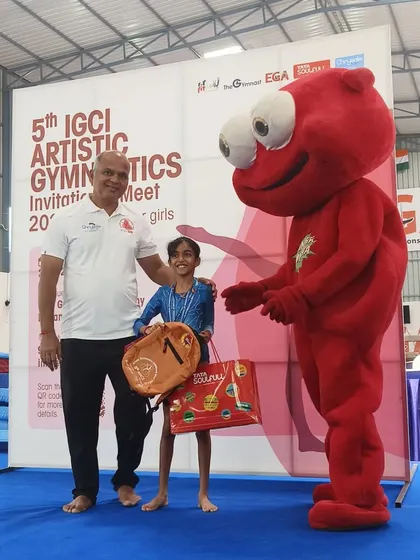 A young gymnast proudly accepts her award at the IGCI invitational meet.