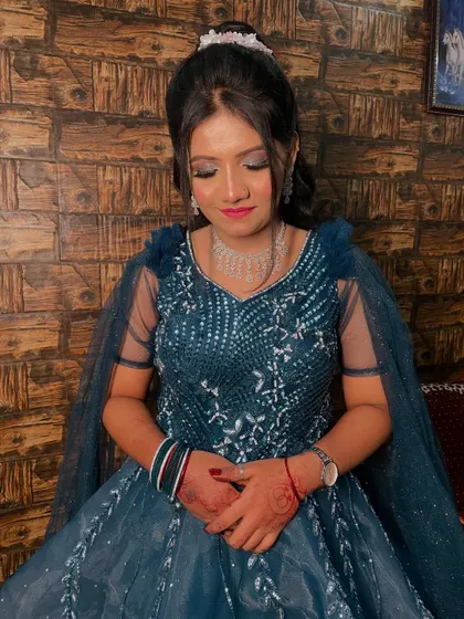 A closer shot of the bride in her teal gown, showing the silver embroidery and the complementary silver-toned eye makeup.