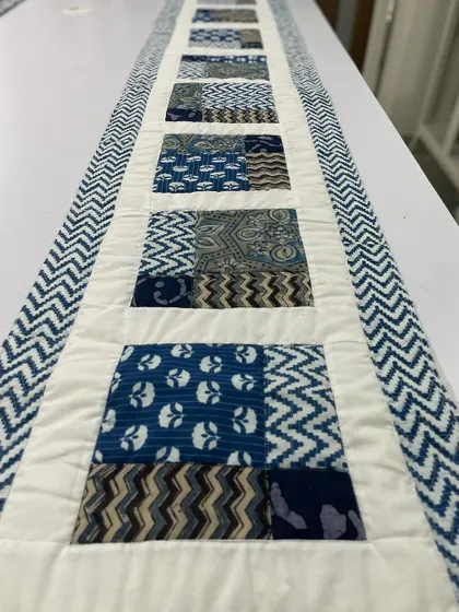 A beautiful table runner made with traditional indigo block-printed fabrics. The simple patchwork design is elegant and timeless.