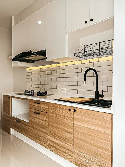 This design showcases a Scandinavian-inspired kitchen with light wood cabinets, a white countertop, and a classic white subway tile backsplash. The open dish rack and minimalist black hardware add to its clean and functional charm.
