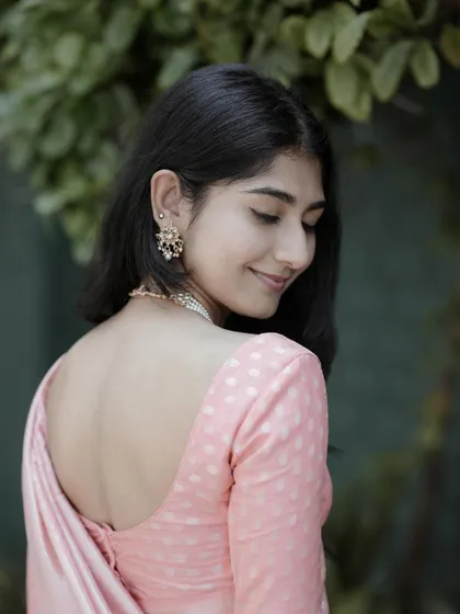 A portrait that is both traditional and modern. The backless blouse and her serene expression create an image of quiet elegance and classy style.