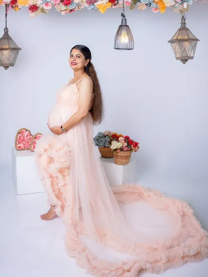 A dreamy solo portrait featuring a delicate peach-colored ruffled gown. The soft textures and colors create a very feminine and gentle image.