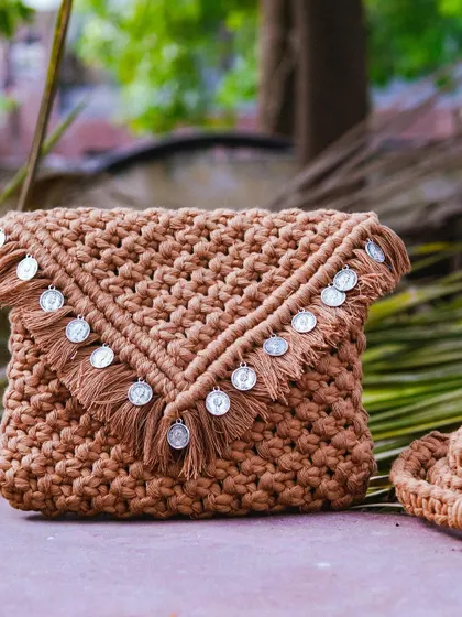 This tan macrame clutch is giving me major vintage vibes with its coin embellishments. 🍂 It's a beautiful, earthy piece that works for both day and evening looks. The detachable strap means you can wear it as a shoulder bag or carry it as a stylish clutch.