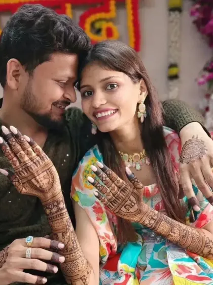 A close-up of the couple from a previous photo, this time showing the detailed bridal mehandi that extends up the forearms.