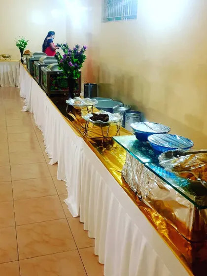 A similar perspective of the buffet line, showing the neat arrangement of dishes and floral decor.