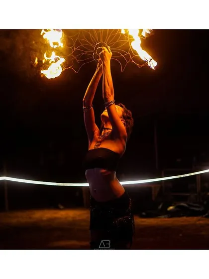 A powerful moment of a fire performer, holding the flames aloft. This shot captures the strength and focus required for such a performance.