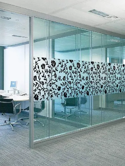 A decorative band of black floral silhouette pattern on a glass office wall. This design offers targeted privacy at eye level while leaving the rest of the glass clear.