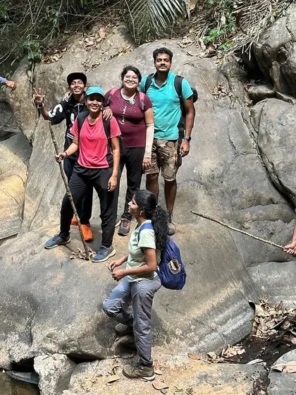 A group crosses a log bridge over a stream. A small but fun challenge on the trail.