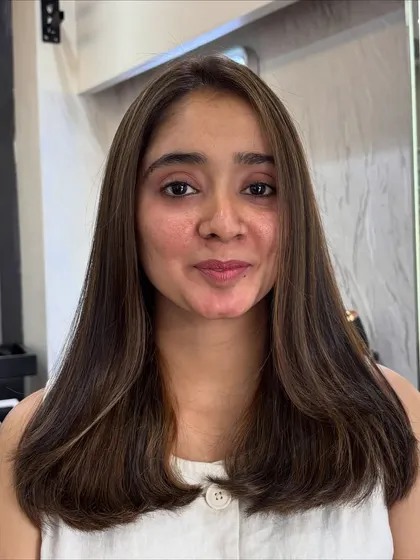 The client's happy face after her subtle Espresso Brown highlight service. It's a fresh new look that enhances her natural beauty.