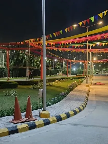 For large open areas, I use overhead fabric drapes and colorful bunting flags to define the event space. This night shot shows how simple drapes can transform a society park or public ground for a festival.