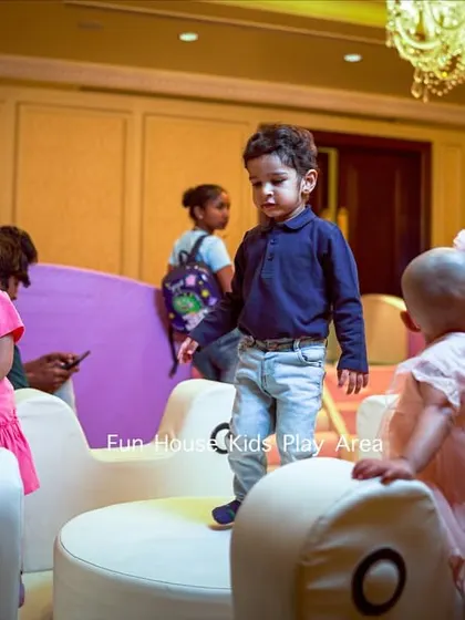 Toddlers exploring the white merry-go-round at an indoor party. Our equipment is designed to be safe and accessible for the littlest guests.