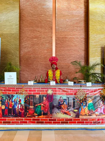 A traditionally dressed staff member at a colourful counter, ready to serve guests in Amritsar. This shows our presence and adaptability in different regions, from Mumbai to Punjab.