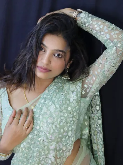 A close-up, artistic shot of Sonu, focusing on the texture of the saree and her expressive look.
