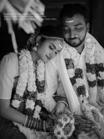 A peaceful black and white portrait of the bride resting her head on the groom's shoulder after the ceremony.