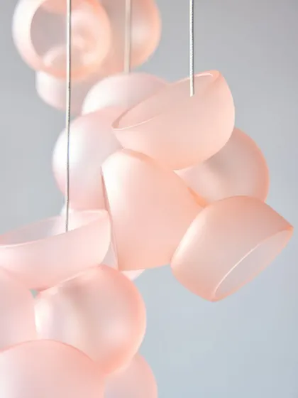 A close-up of the new pink Bocci 100 pendants, their soft, frosted finish and delicate color creating a beautiful, ethereal effect.