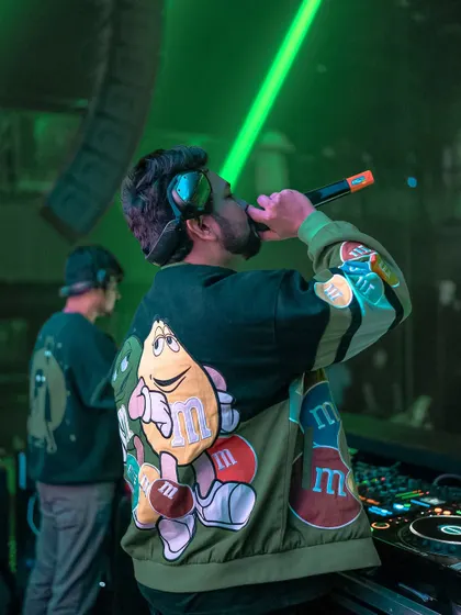 On the mic in Goa, wearing my M&M jacket. It's about bringing personality and fun to the stage.