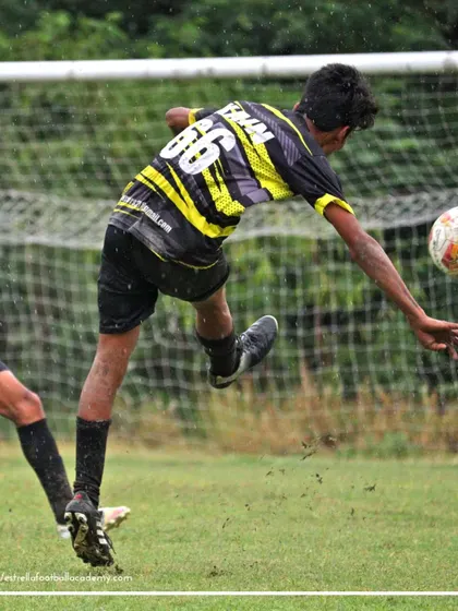 A player executing a flying kick to connect with the ball during a B Division league match. This demonstrates the high level of skill and athleticism of our senior players.
