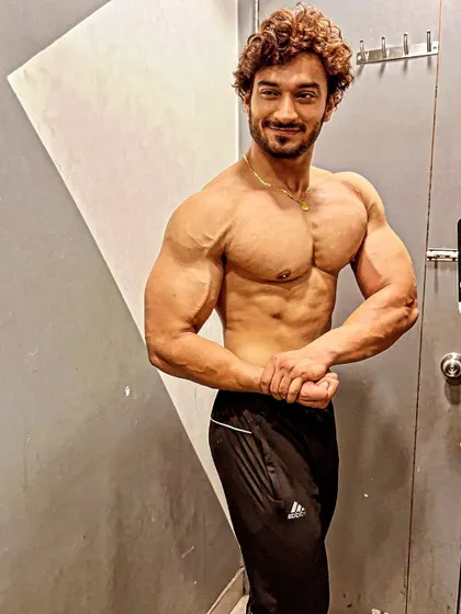 A smiling, confident pose showing my chest and arm development.