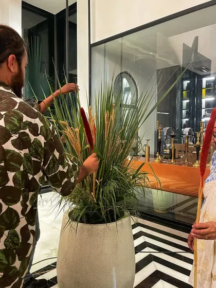 The team putting the finishing touches on a large arrangement of reeds and grasses in a modern white planter for one of the scenes.