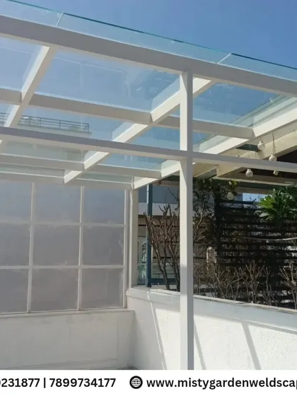 Another angle of the toughened glass pergola, showing its sleek white frame and how it integrates seamlessly with the villa's architecture.