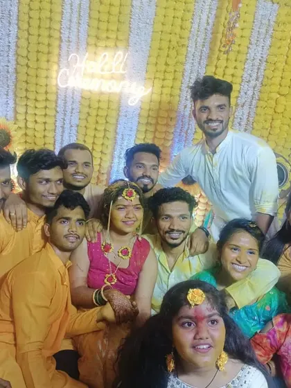 The Haldi ceremony is all about fun with friends and family. A happy group photo in front of the marigold wall.