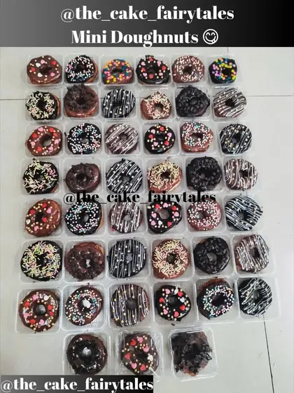 A big batch of my freshly baked mini donuts, all ready for a party. You can see the variety of toppings I offer, from chocolate drizzles and heart sprinkles to colorful strands and choco chips.