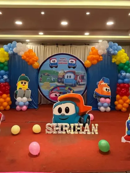 All aboard for a fun construction truck themed party. This setup is perfect for little vehicle lovers, featuring a custom backdrop and large cutouts of colorful, friendly trucks, framed by bright balloon arches.