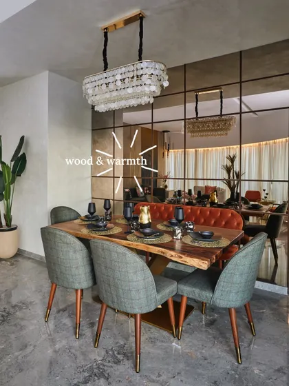 This dining room showcases the beauty of wood and warmth. A solid wood dining table pairs with matching cabinetry, bringing an earthy richness that is balanced by modern colorful chairs and a statement chandelier.