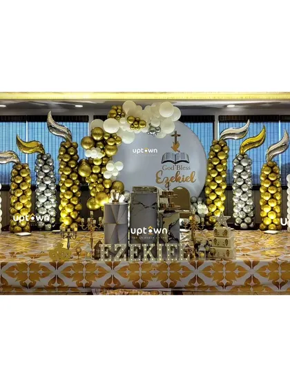 A grand Baptism setup for Ezekiel with gold and white balloon pillars shaped like candles.