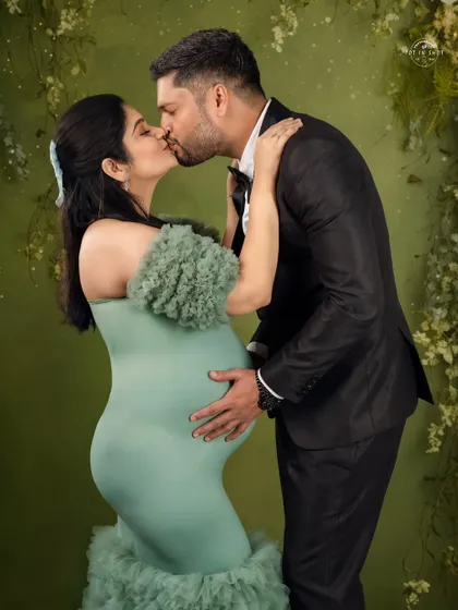 A passionate kiss shared between the expecting couple, a beautiful expression of their love story.